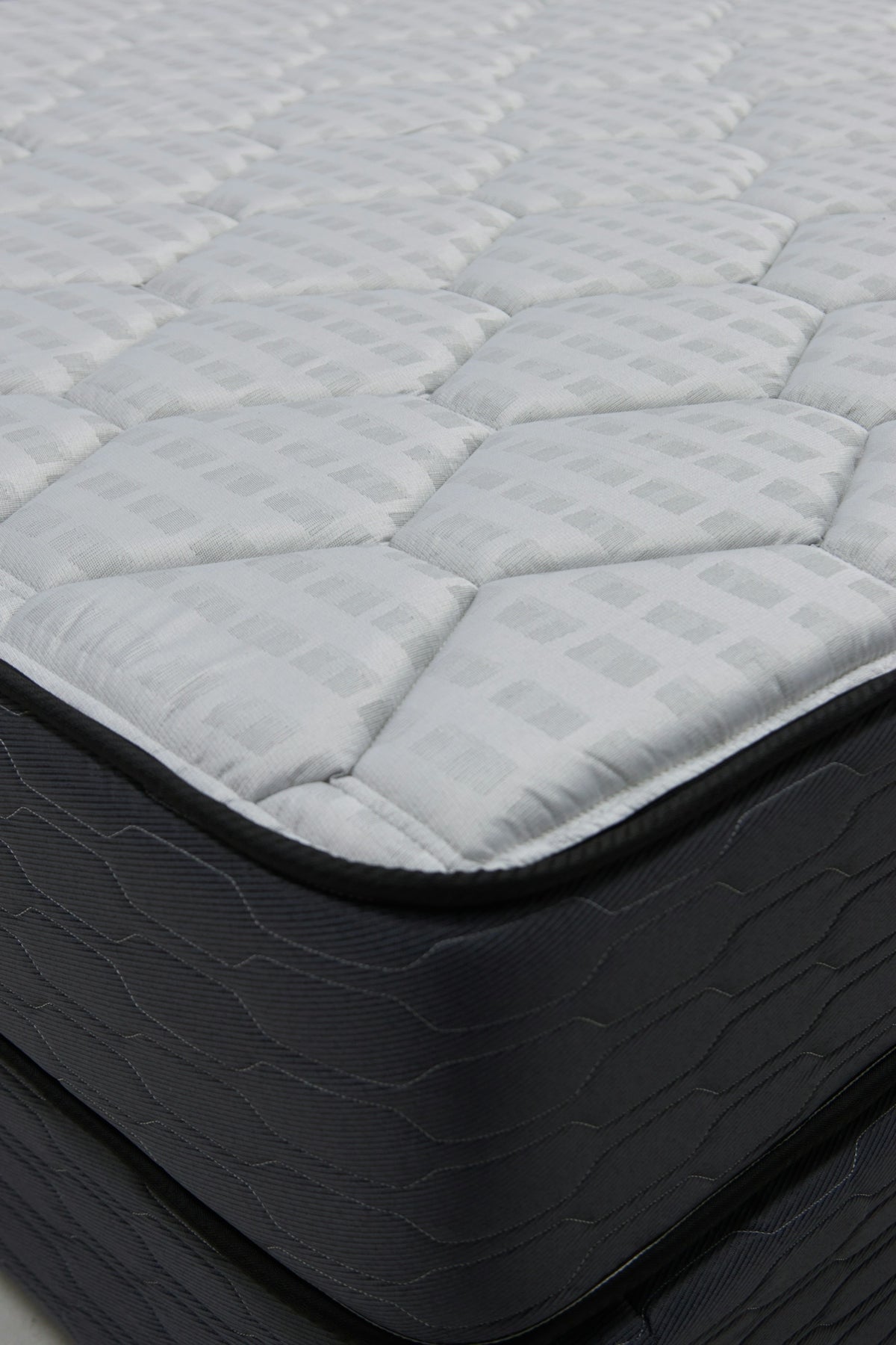 Close-up of a quilted mattress with dark sides